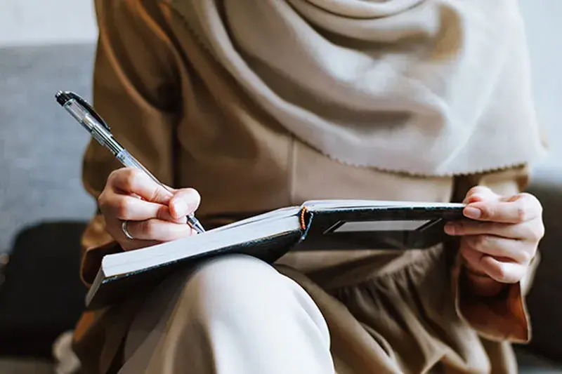 Lady is writing on notebook